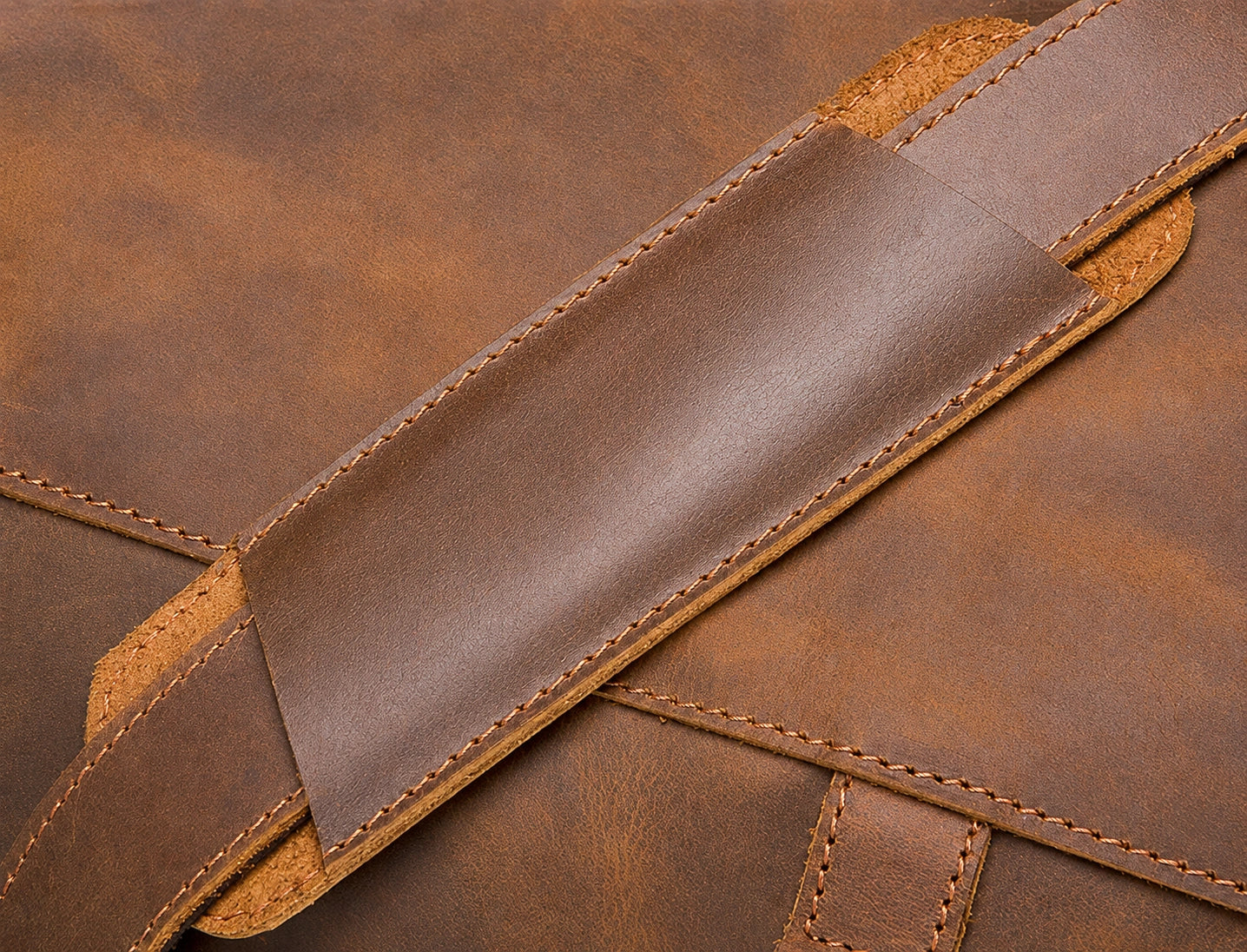 Adjustable leather shoulder strap detail on travel duffel