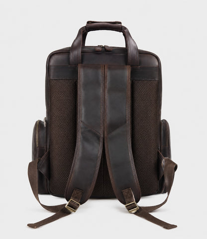 Dark brown leather camera backpack rear view with adjustable padded shoulder straps and mesh back panel, high-quality brass hardware, straps for tripod attachment, professional DSLR storage.