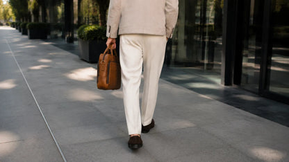 Man carrying vintage leather briefcase in urban setting
